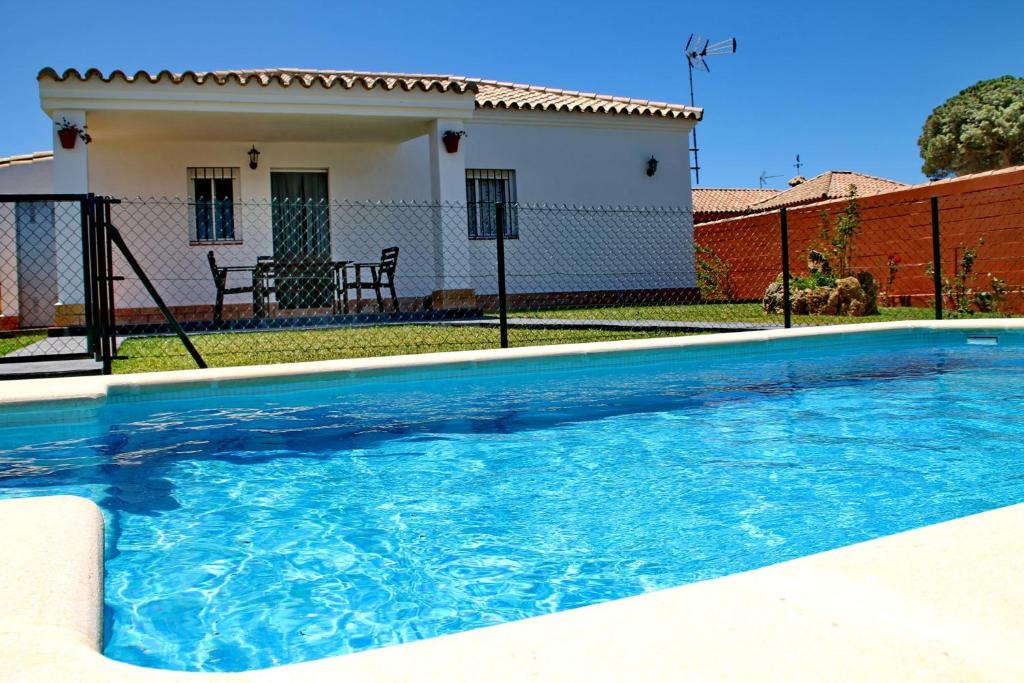 a swimming pool in front of a house at Chalet Cala de Roche in Roche