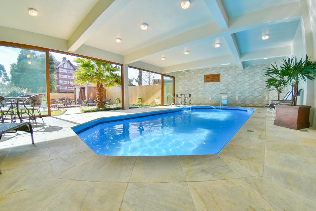 una gran piscina con una gran bañera azul en una habitación en Pousada Ares da Serra - Centro, en Gramado