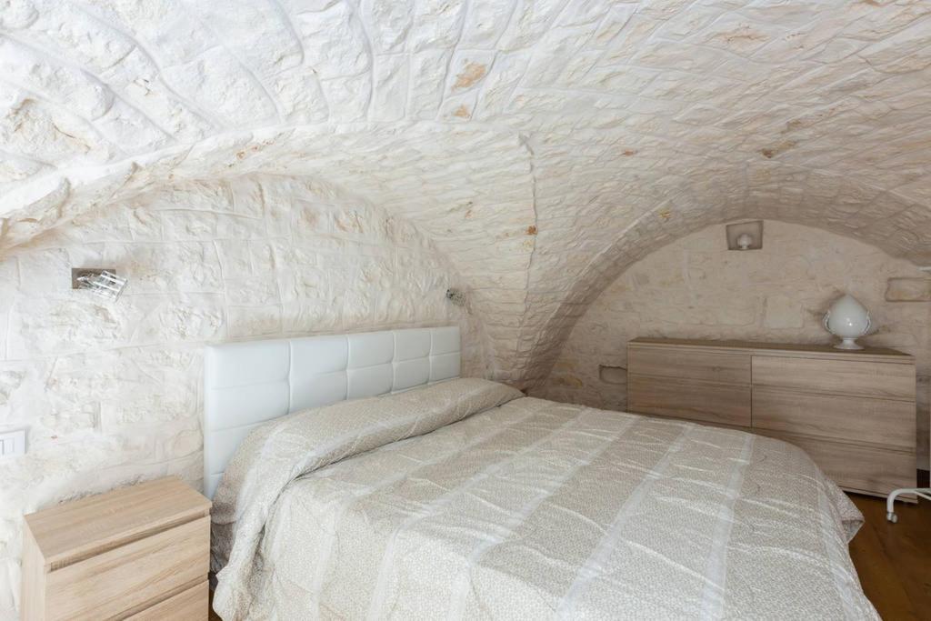 オストゥーニにあるDimora Alfonso Pomesの石壁のベッドルーム1室