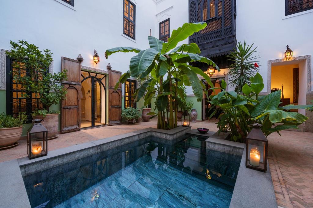 ein Pool in der Mitte eines Hauses mit Pflanzen in der Unterkunft Riad Azzar in Marrakesch