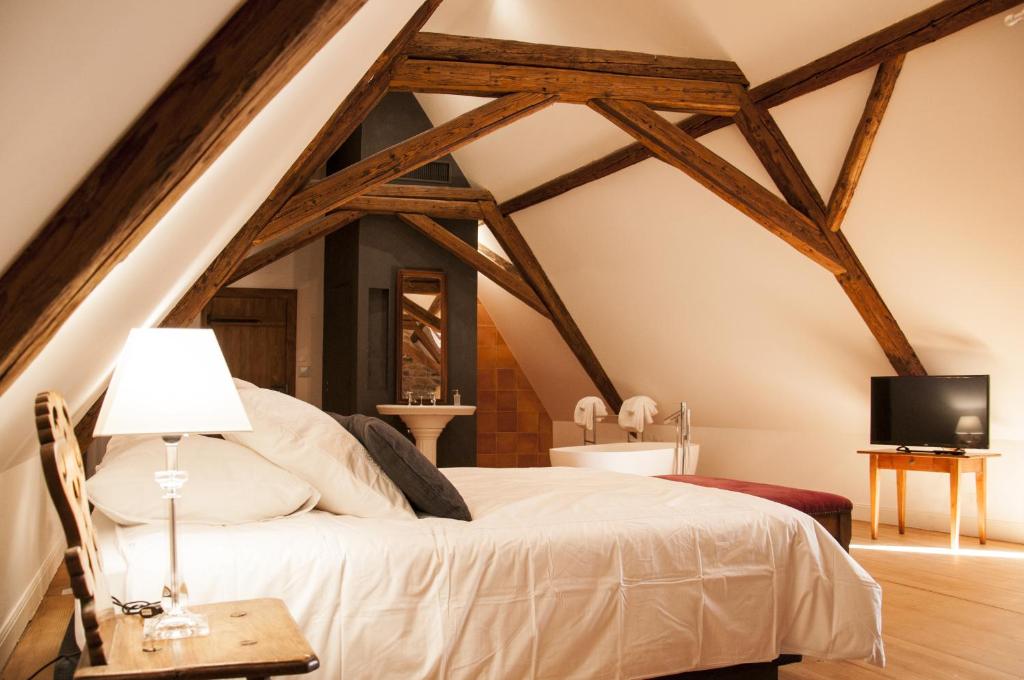 a bedroom with a white bed and a tv at Unter der Linde in Nordheim