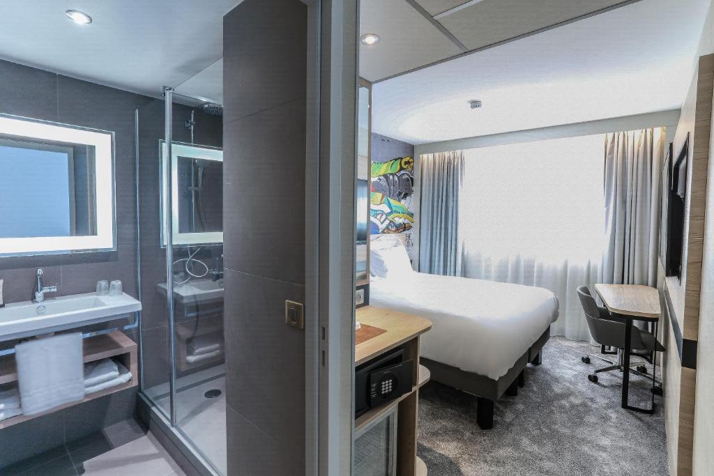 um quarto de hotel com uma cama e um lavatório em Arena Hotel La Defense em Nanterre