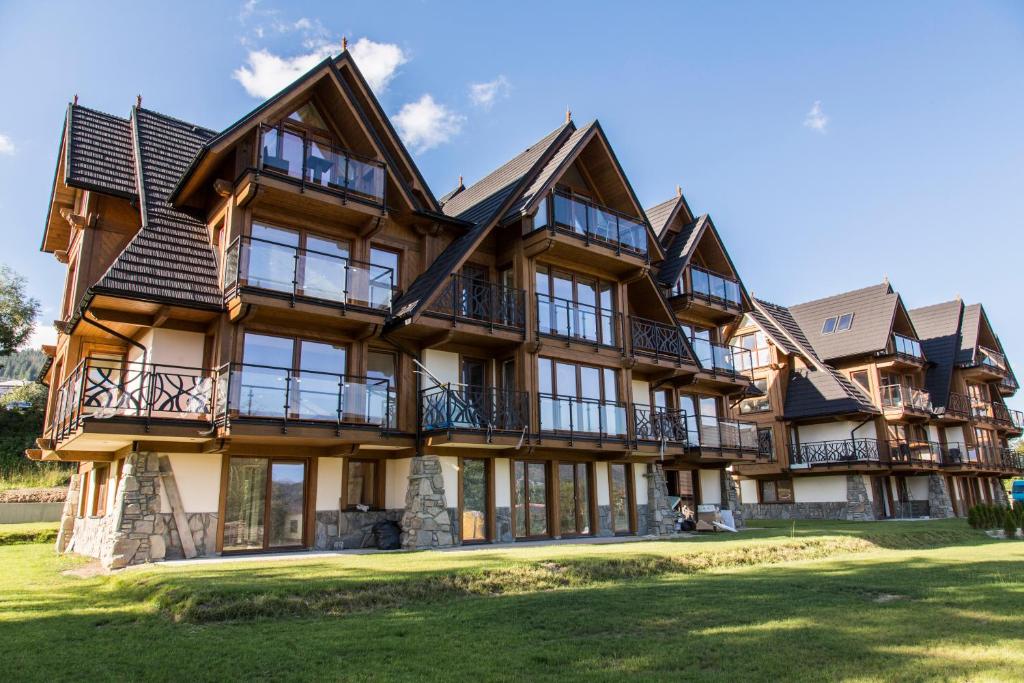 une grande maison en bois avec une grande cour dans l'établissement Apartament PAJO III Ski RESORT, à Zakopane