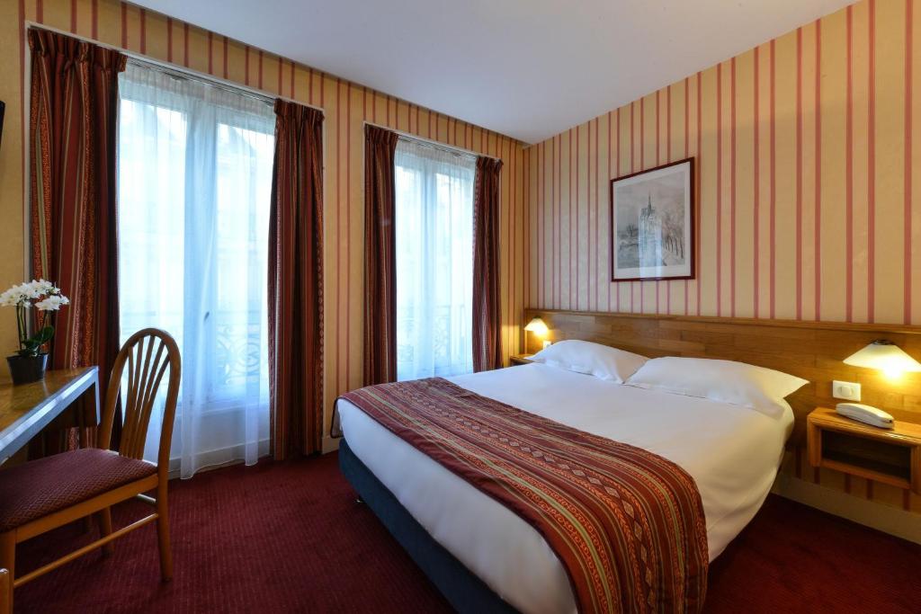 Cette chambre comprend un grand lit et une fenêtre. dans l'établissement Relais du Pré, à Paris