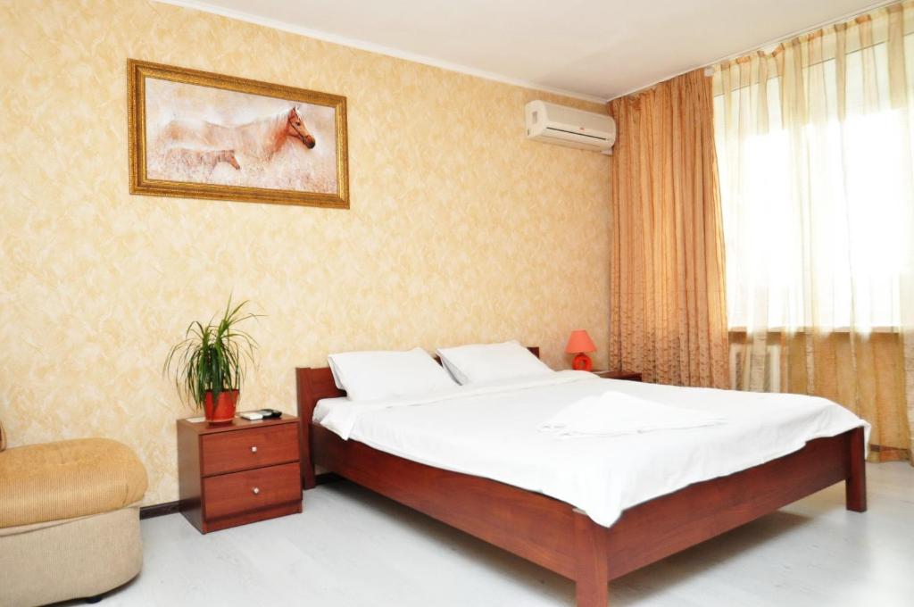1 dormitorio con 1 cama, 1 silla y 1 ventana en Dayflat Apartments on the Left Bank, en Kiev