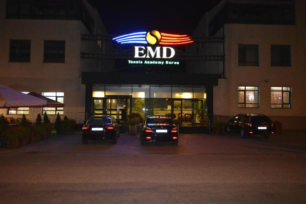 a store with cars parked in front of it at night at Hotel EMD in Bacău