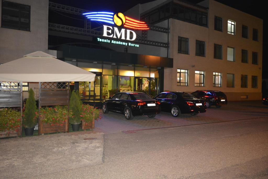 a group of cars parked in a parking lot in front of a building at Hotel EMD in Bacău