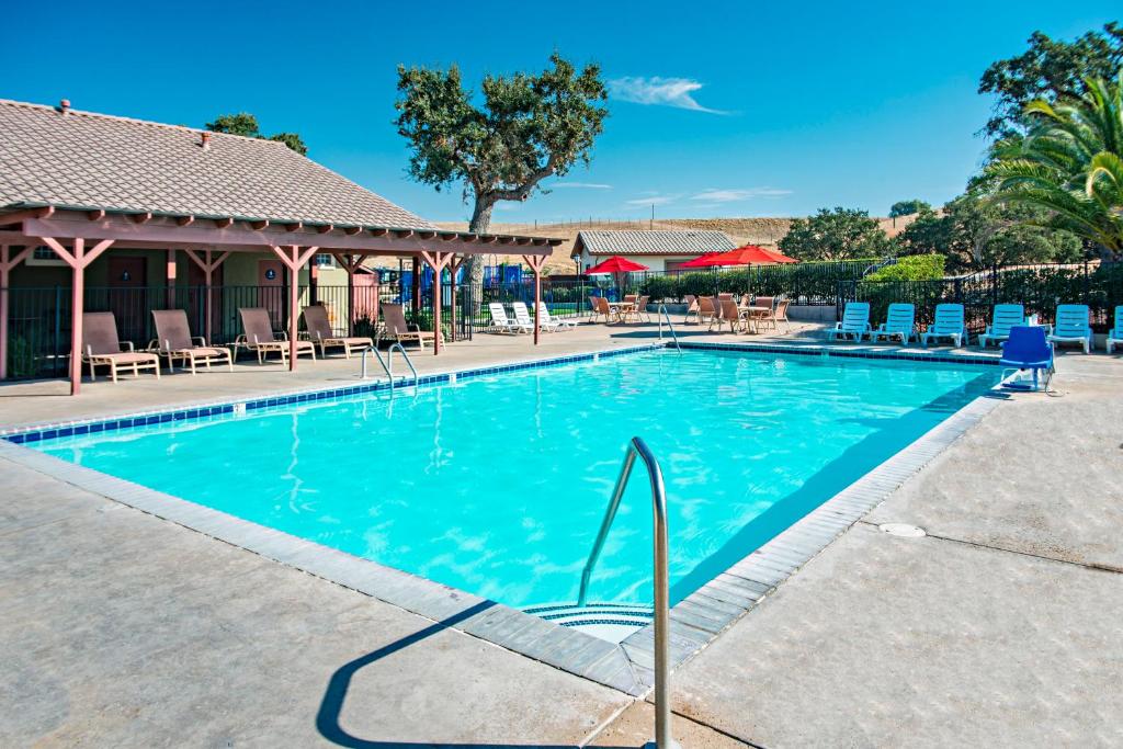 a swimming pool at a resort with chairs at Sun Outdoors Central Coast Wine Country in Paso Robles
