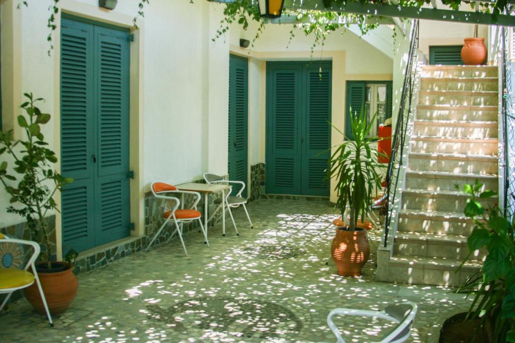 eine Terrasse mit grünen Türen und Stühlen sowie einem Tisch in der Unterkunft George Apartments in Livadia