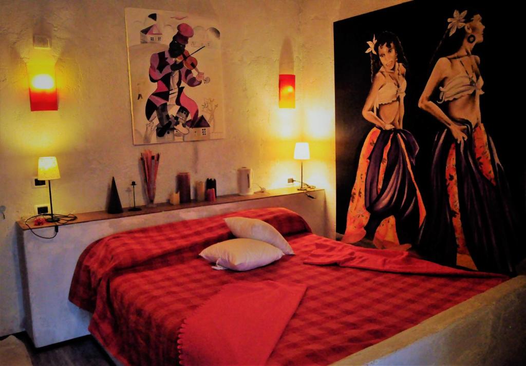 Un dormitorio con una cama roja con una pintura en la pared en premiata osteria dei fiori, en Cortiglione