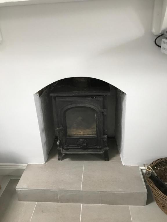 a fireplace in the corner of a room at Hobbit Hollow in Ballymore Eustace