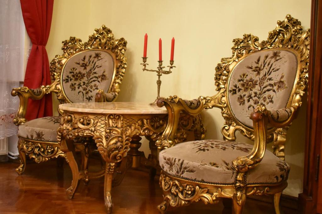 an ornate dining room with a table and two chairs at History Apartments Cetății in Sibiu