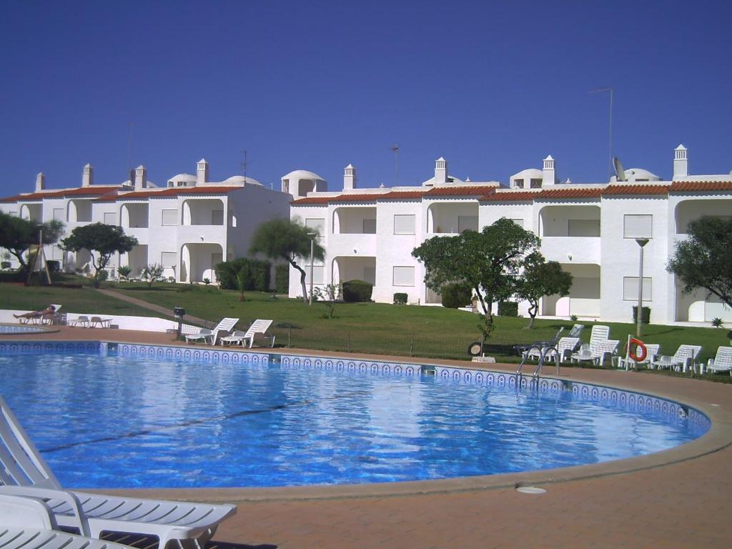 a large swimming pool in front of a building at Apt com piscina em Alporchinhos in Lagoa