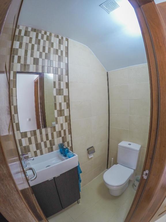 a bathroom with a toilet and a sink and a mirror at Casa Zen in Puerto Calero