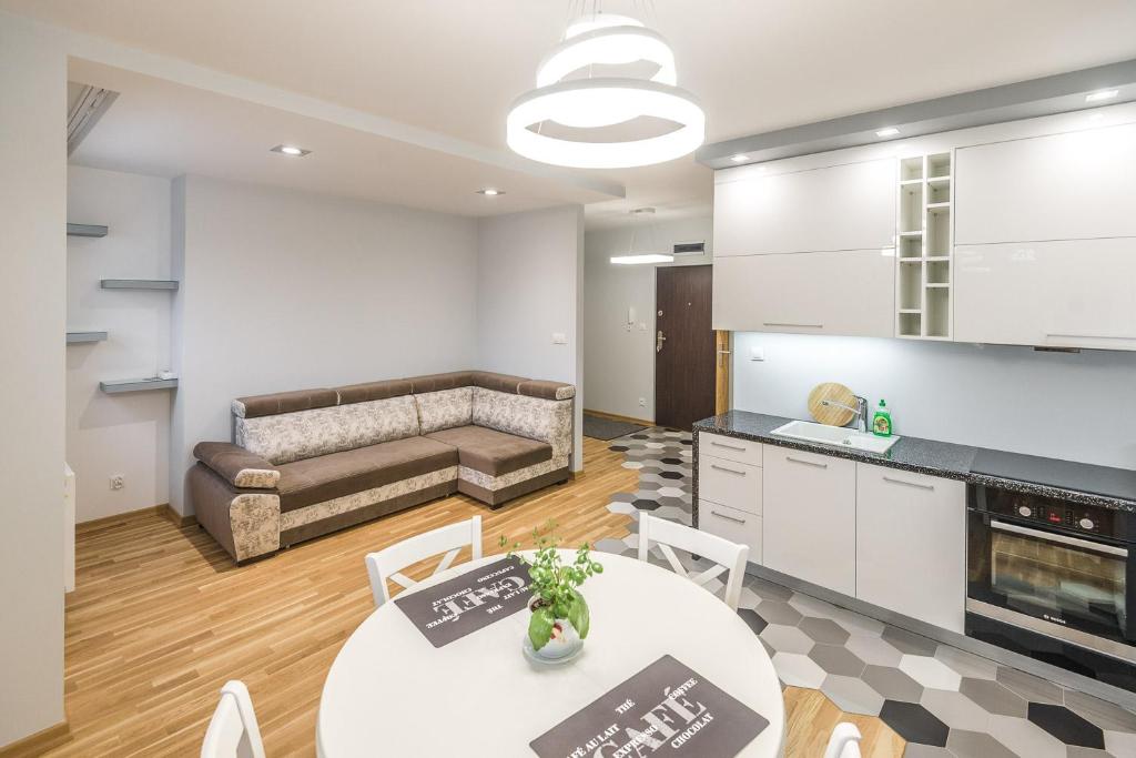 een keuken en een woonkamer met een bank op de achtergrond bij Apartament 48m w centrum Grójca in Grójec