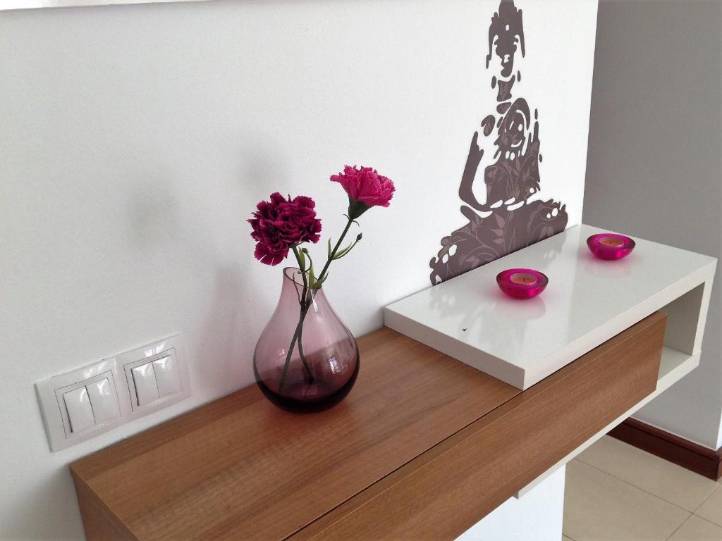 a vase sitting on a table with flowers in it at Casa Zen in Puerto Calero
