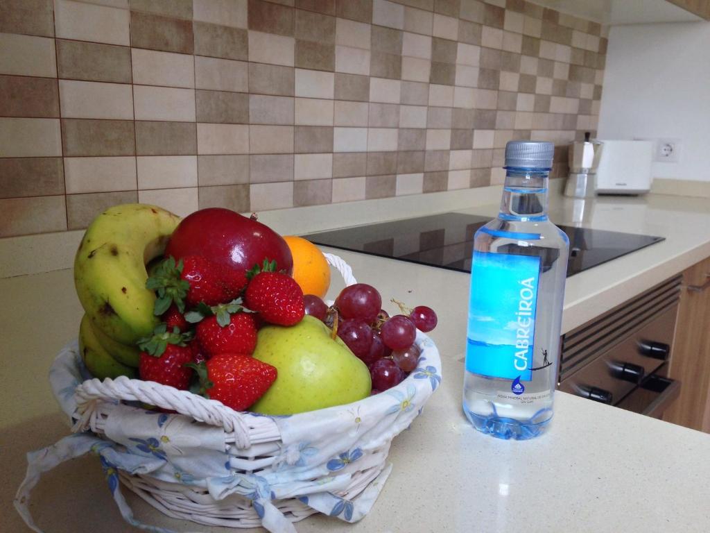 a bottle of water sitting next to a basket of fruit at Casa Zen in Puerto Calero