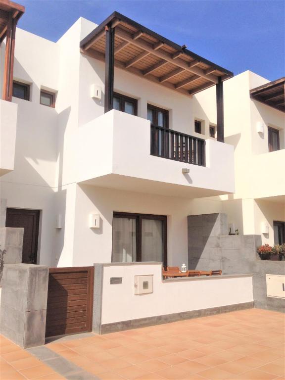 a white house with a balcony at Casa Zen in Puerto Calero