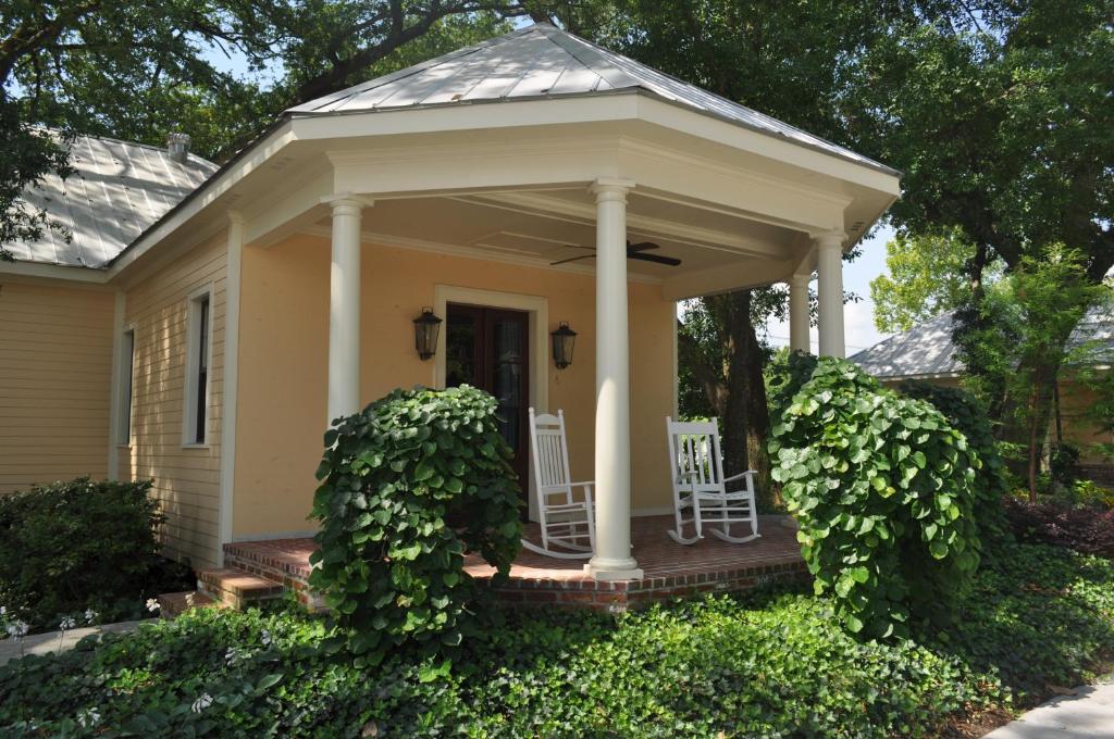 a small yellow house with two chairs on a porch at The Inn at Houmas House Estate in Darrow