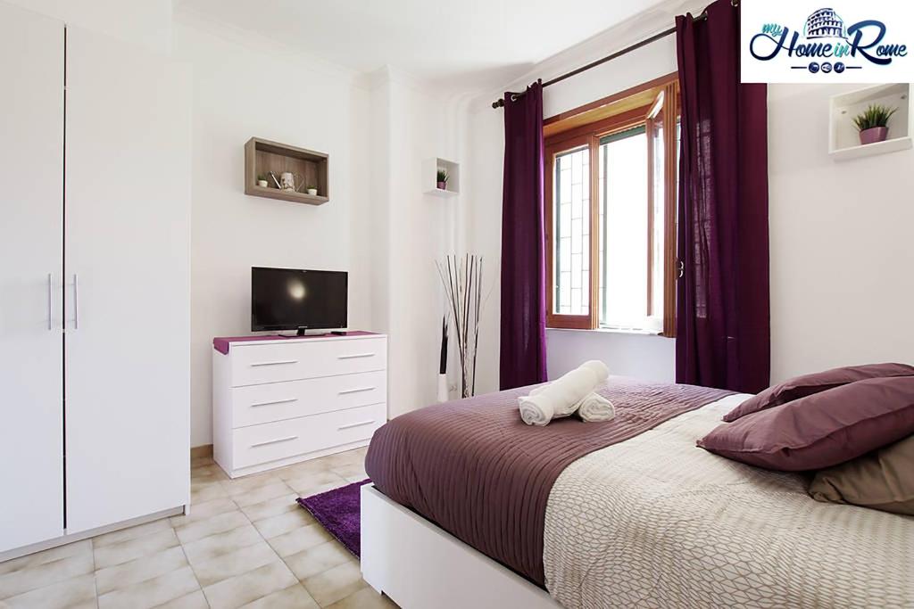 - une chambre blanche avec un lit et une télévision dans l'établissement Appartamento di Nina, à Rome