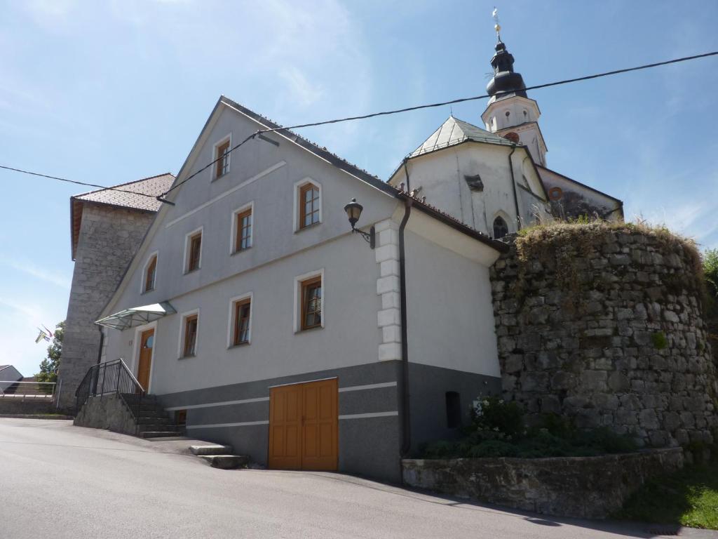um grande edifício branco com um campanário da igreja em Apartments Tabor43 em Cerknica