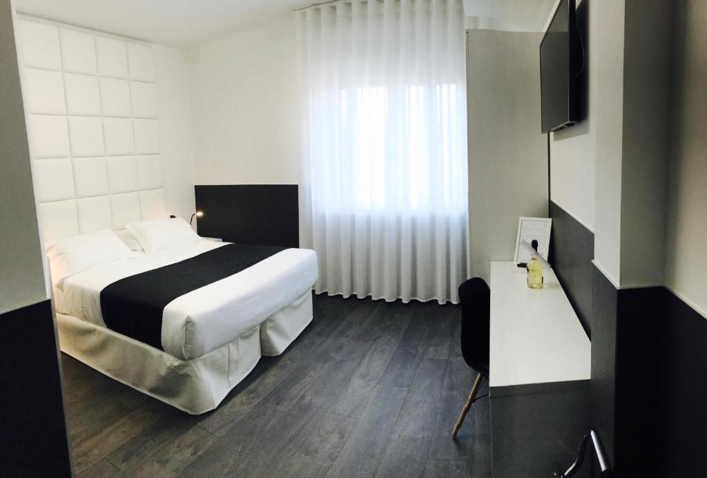 ルバーノにあるHotel Pex Padovaのベッドとテレビが備わるホテルルームです。