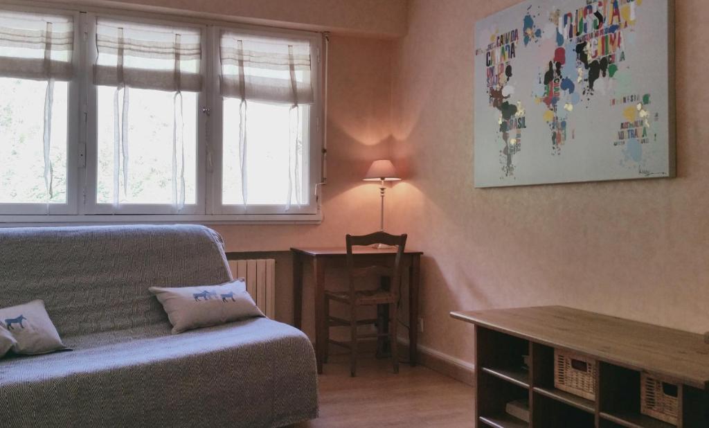 a bedroom with a bed and a table and a window at T2 Bis Luchon in Luchon