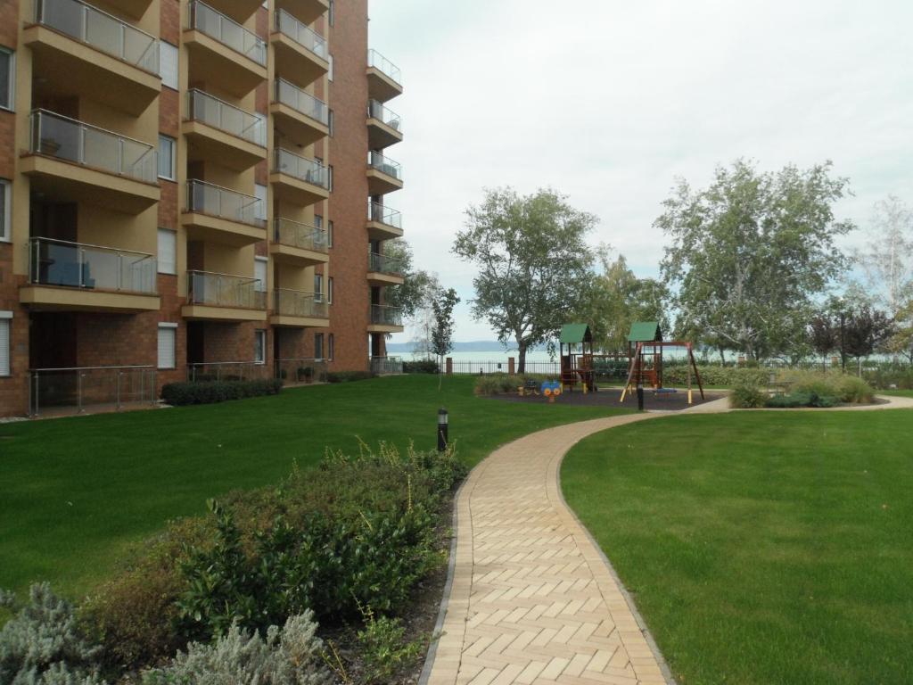 a park next to a building with a playground at Galerius Apartment in Siófok