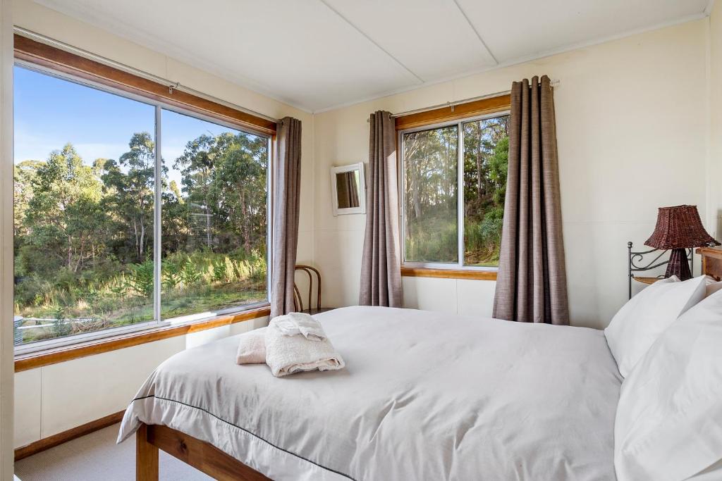 a bedroom with a bed and a large window at Summertime Cottage in Southport