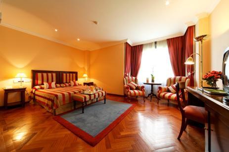 duży pokój z łóżkiem i salonem w obiekcie Don Pio w Madrycie