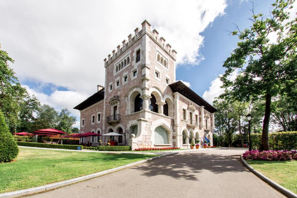 ein Gebäude mit einem Turm an der Seite einer Straße in der Unterkunft Castillo Del Bosque La Zoreda in Manjoya