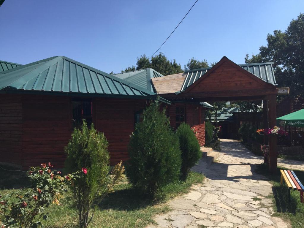 a wooden house with a green roof at Etno Restoran Ranc in Radibuš