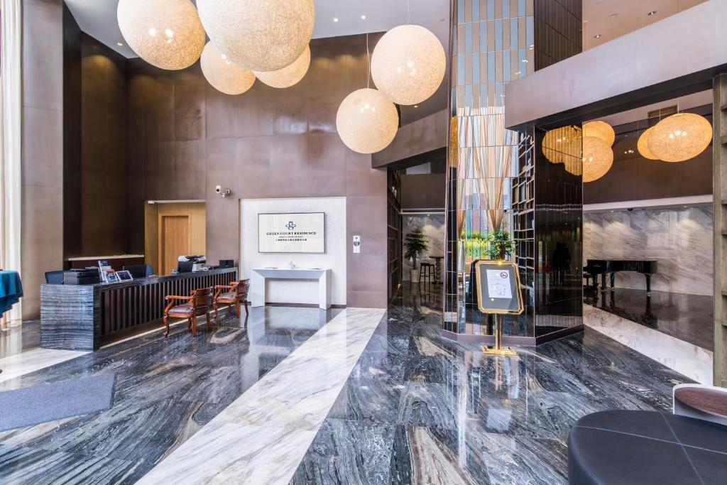 a lobby of a hotel with chandeliers at Green Court Residence Jinqiao Diamond Shanghai in Shanghai