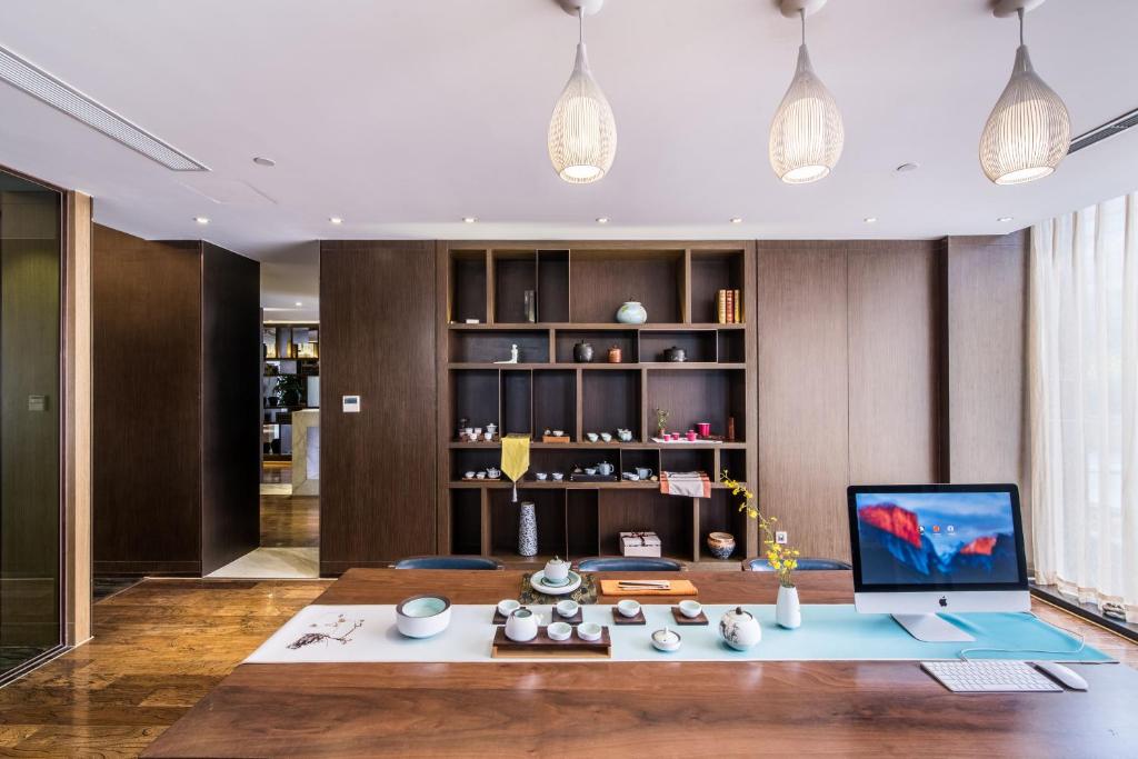 a living room with a desk with a computer on it at Green Court Residence Jinqiao Diamond Shanghai in Shanghai