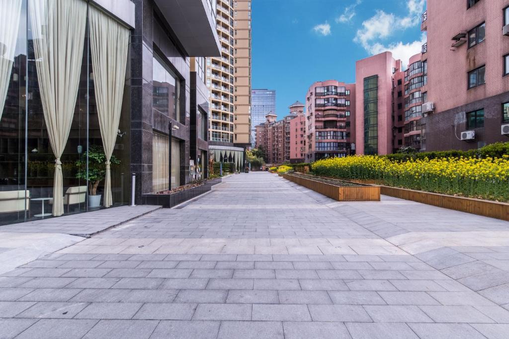 an empty street in a city with tall buildings at Green Court Residence Jinqiao Diamond Shanghai in Shanghai