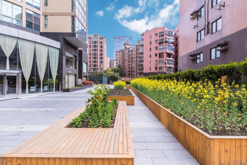 a city street with a row of plants and buildings at Green Court Residence Jinqiao Diamond Shanghai in Shanghai