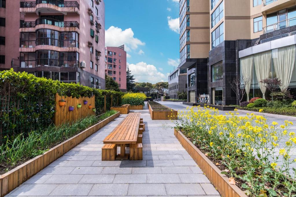 a row of benches in a city with buildings at Green Court Residence Jinqiao Diamond Shanghai in Shanghai