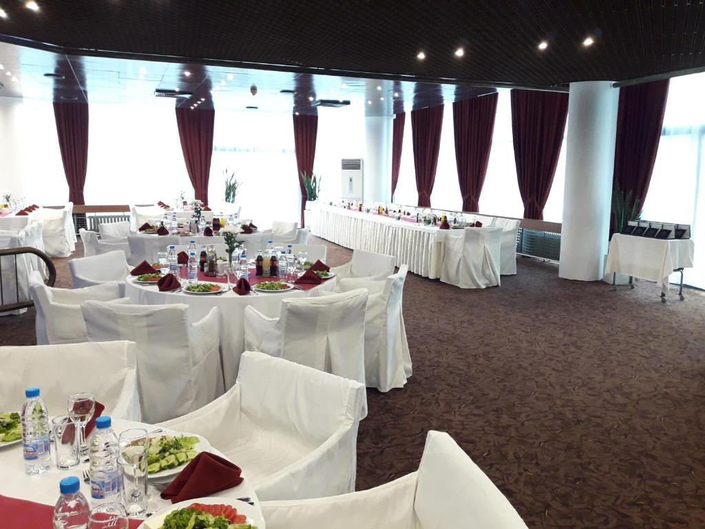 un salón de banquetes con mesas blancas y sillas blancas en Hotel Lovech, en Lovech