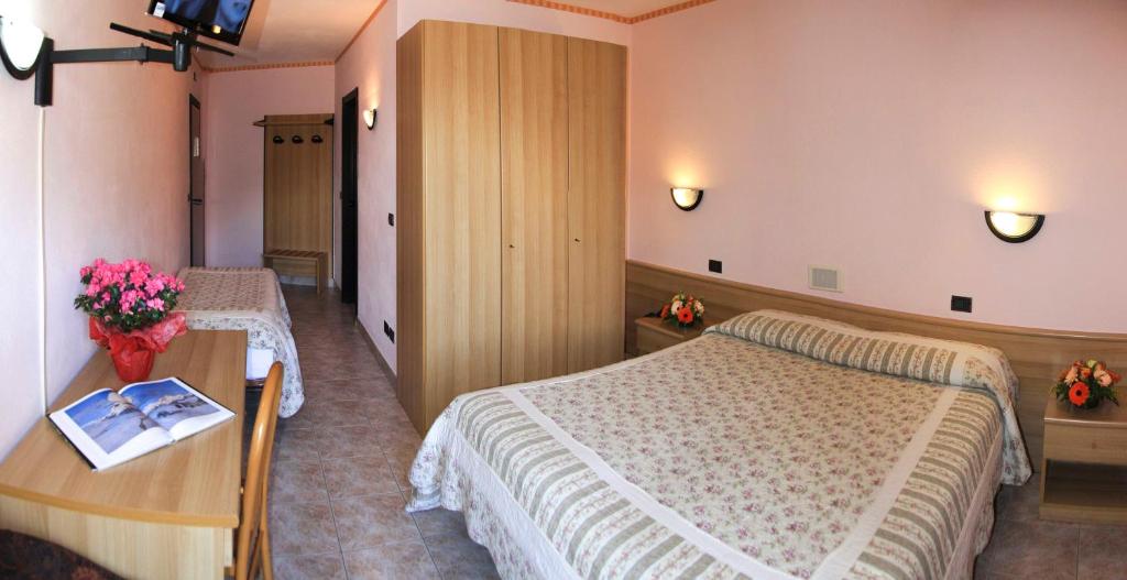 Habitación de hotel con 2 camas y mesa en Hotel Les Saisons, en Saint Vincent