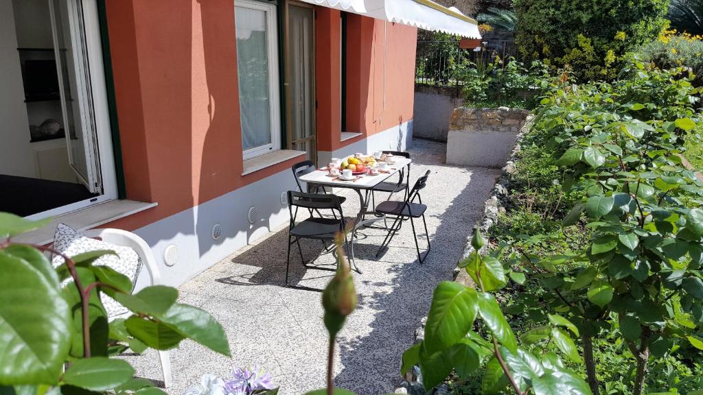 d'une terrasse avec une table et des chaises dans le jardin. dans l'établissement Casa Agrumeto by Holiday World, à Gênes