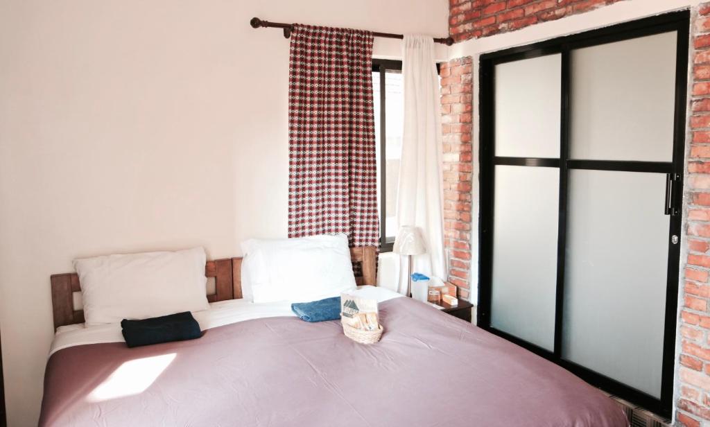 um quarto com uma cama e uma parede de tijolos em Five14 B&B em Patan