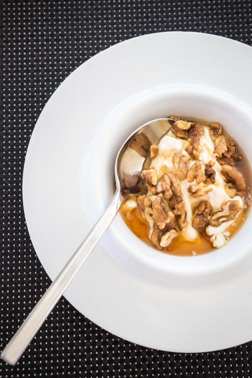 a bowl of oatmeal with a spoon on a plate at Amyth of Mykonos Super Paradise in Super Paradise Beach