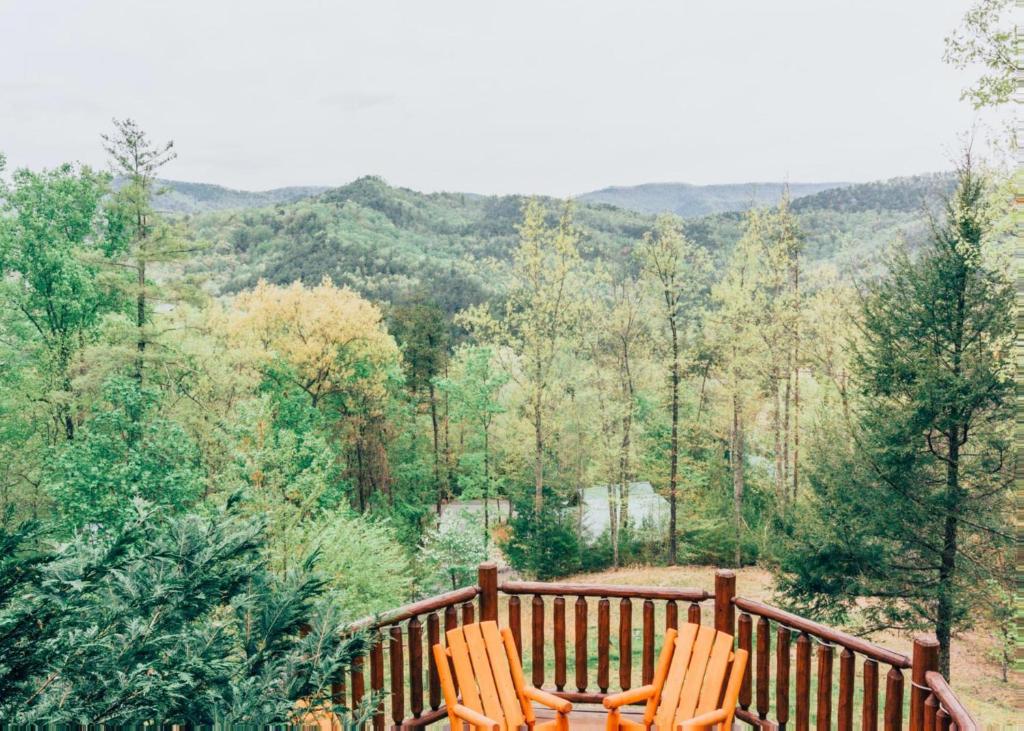 two chairs sitting on a wooden deck in the woods at Heaven's View #20 in Sevierville