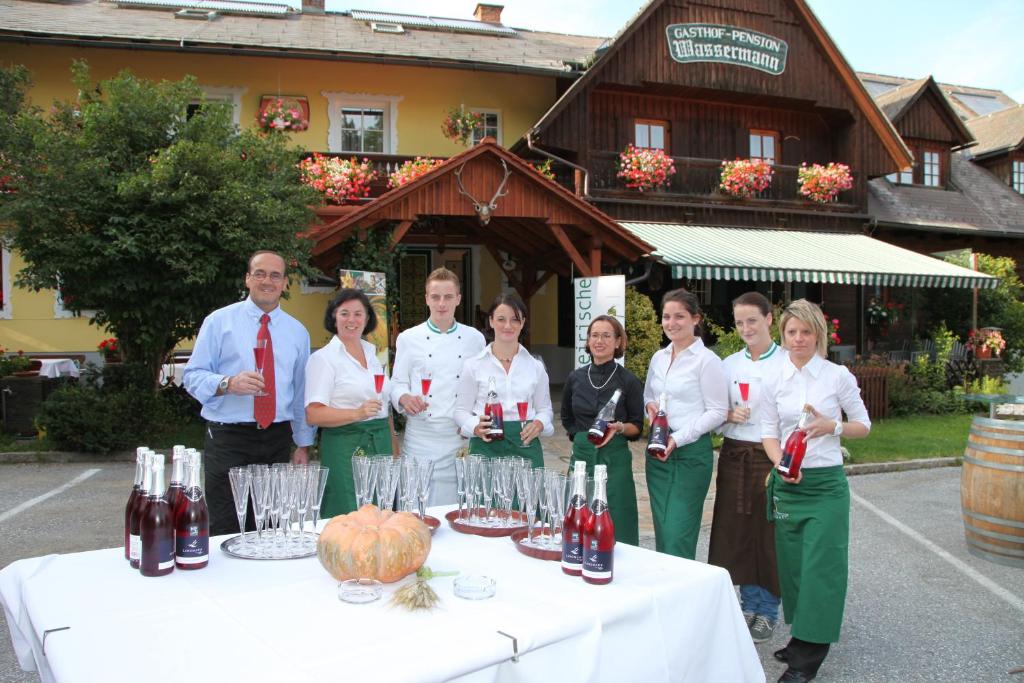 a group of people standing next to a table with wine glasses at Bioalm Wassermann Wirt in Sommereben