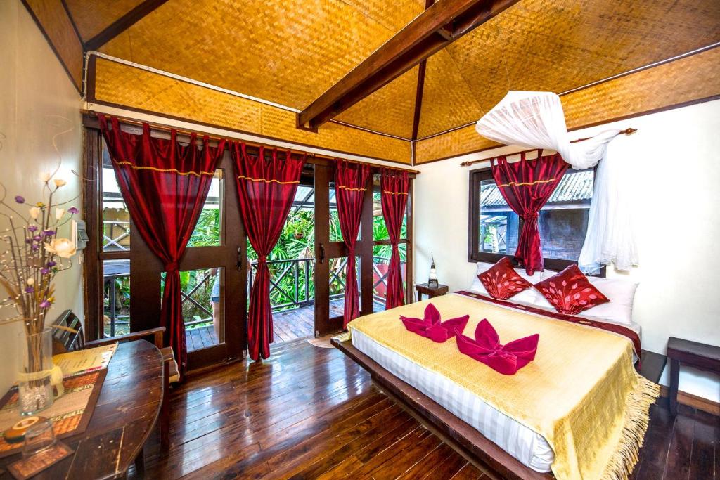 Un dormitorio con una cama con arcos rojos. en Fruit Tree Lodge, en Ko Lanta