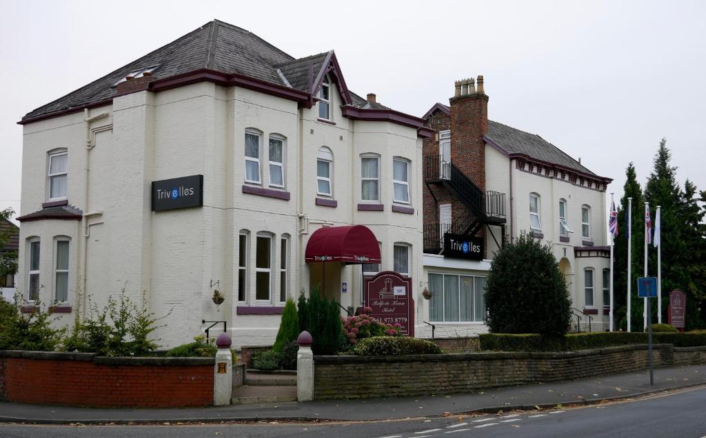 a large white house with a sign on it at Trivelles Belforte Hotel , Sale, Manchester - M33 2AE in Sale