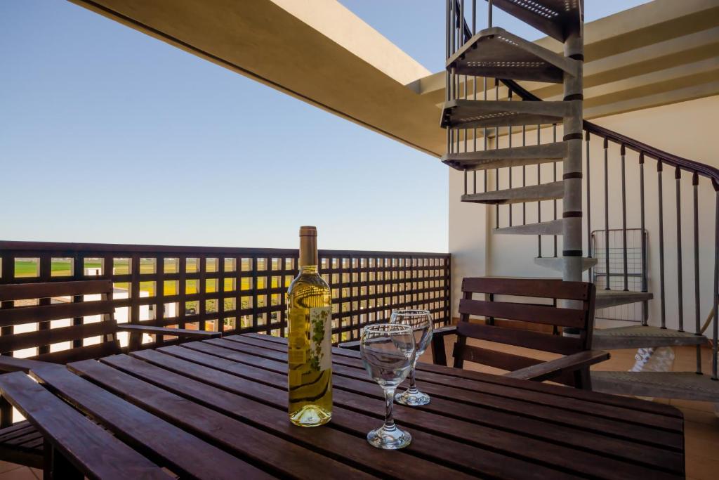 a bottle of wine and a glass on a wooden table at Apartamento Levante in Conil de la Frontera