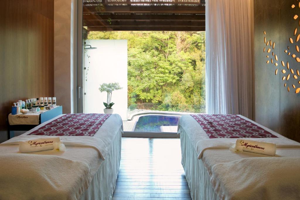 two beds in a room with a view of a pool at Casale Panayiotis in Kalopanayiotis