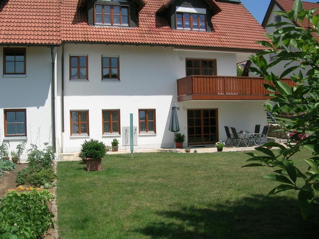 a white house with a red roof and a yard at Ferienwohnung Familie Sinn in Pappenheim