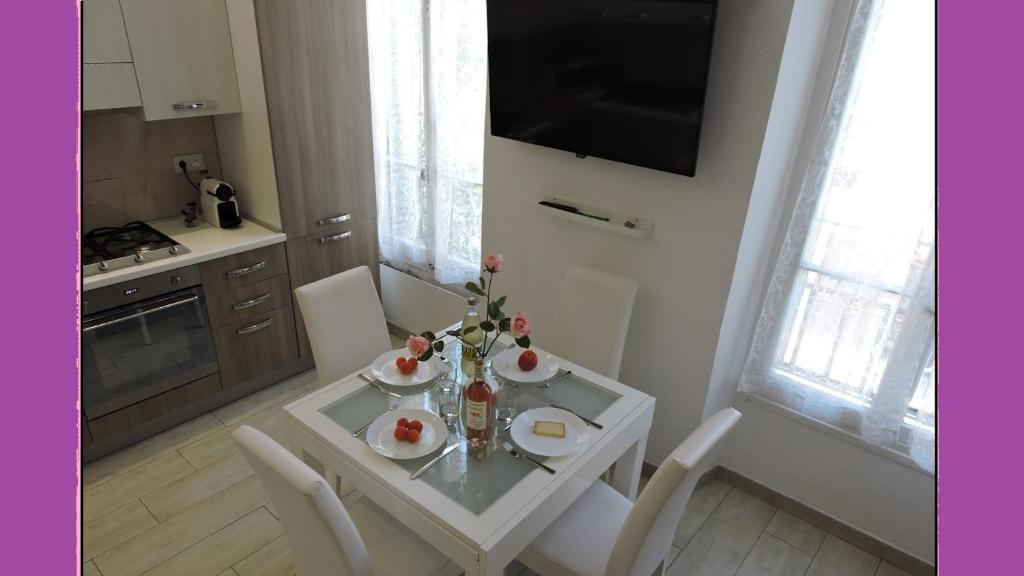 ニースにあるNICE/NIZZA : Apartment (3 rooms + max 6 persons)の白いダイニングテーブル(花付)